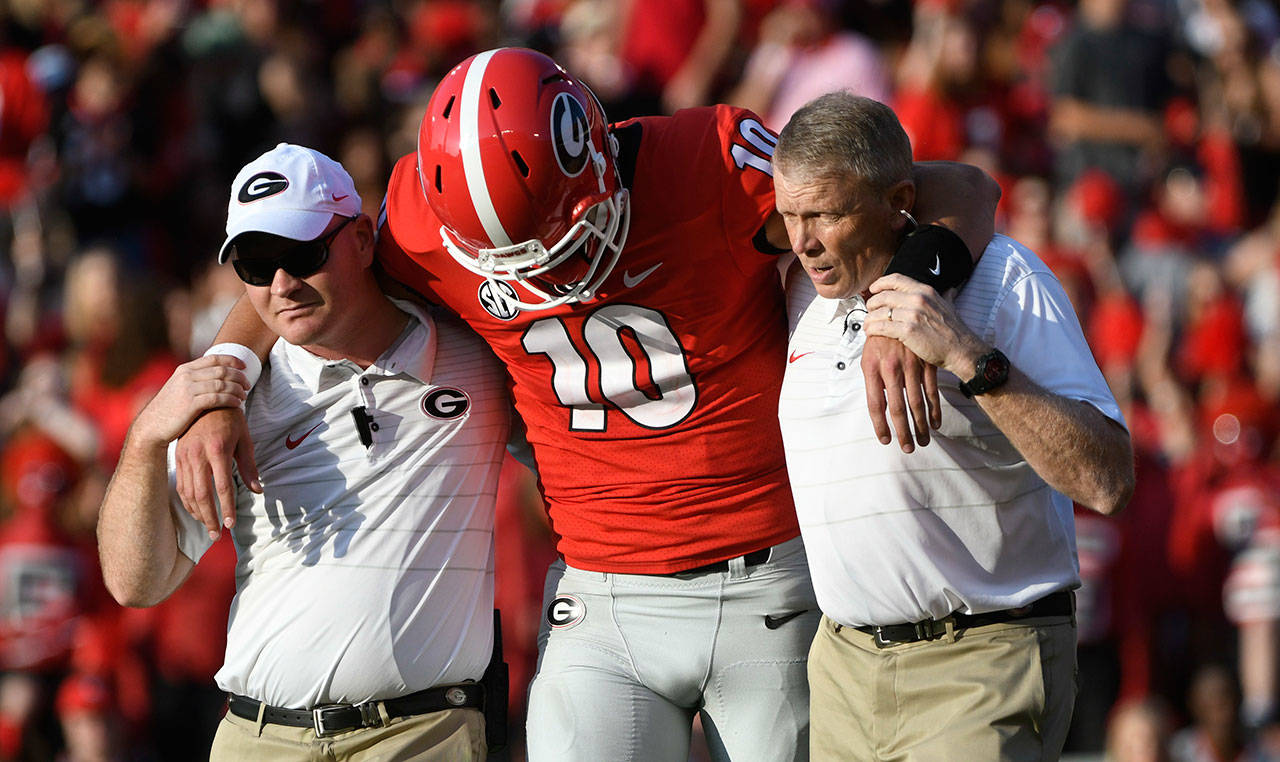 Georgia quarterback Jacob Eason (10), a Lake Stevens alum, is helped off the field after an injury during the first quarter of a game against Appalachian State on Sept. 2, 2017, in Athens, Ga. (AP Photo/John Amis)