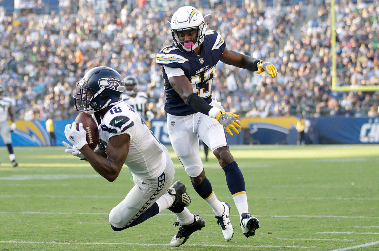 Former Seahawks receiver Kasen Williams (18) makes a catch as Chargers cornerback Michael Davis defends during the first half of a preseason game Aug. 13, 2017, in Carson, Calif. (AP Photo/Jae C. Hong)