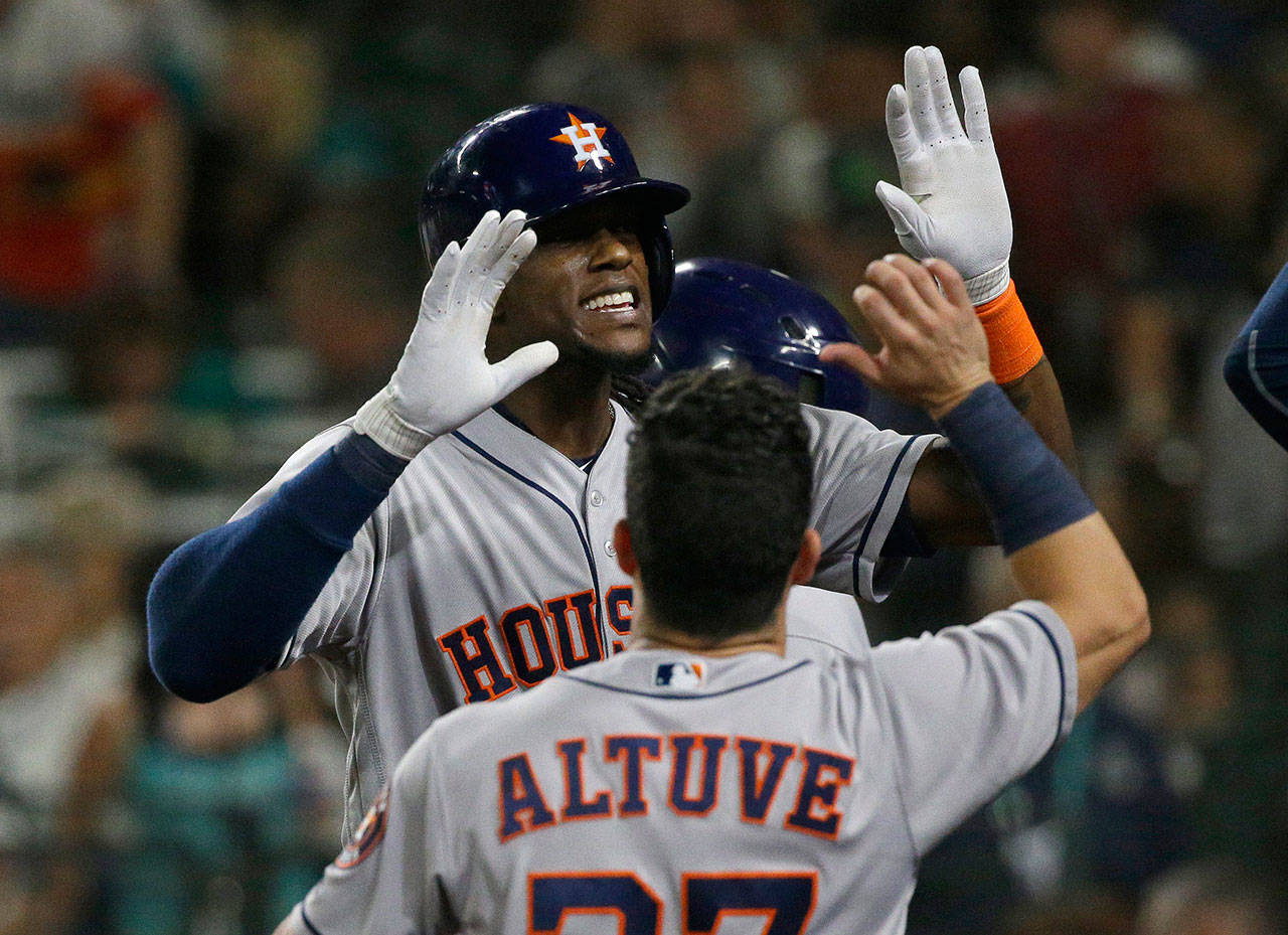 The Astros’ Cameron Maybin (rear) is greeted by Jose Altuve after Maybin hit a two-run home run during the seventh inning of a game against the Mariners Sept. 5, 2017, in Seattle. (AP Photo/Ted S. Warren)