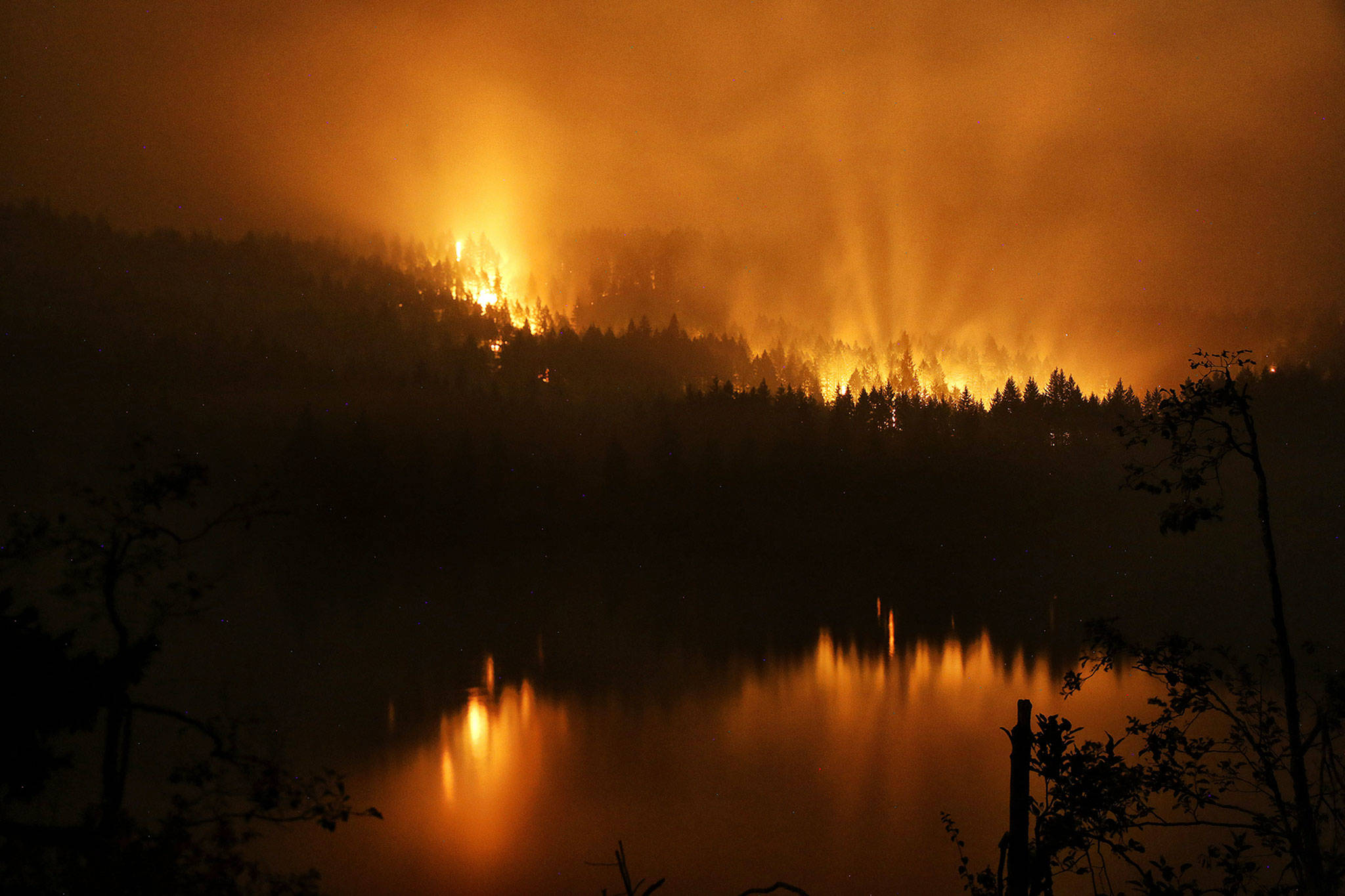 A wildfire burns on the Oregon side of the Columbia River Gorge near Cascade Locks, Oregon, and the Bridge of the Gods late Tuesday. (Genna Martin/seattlepi.com via AP)