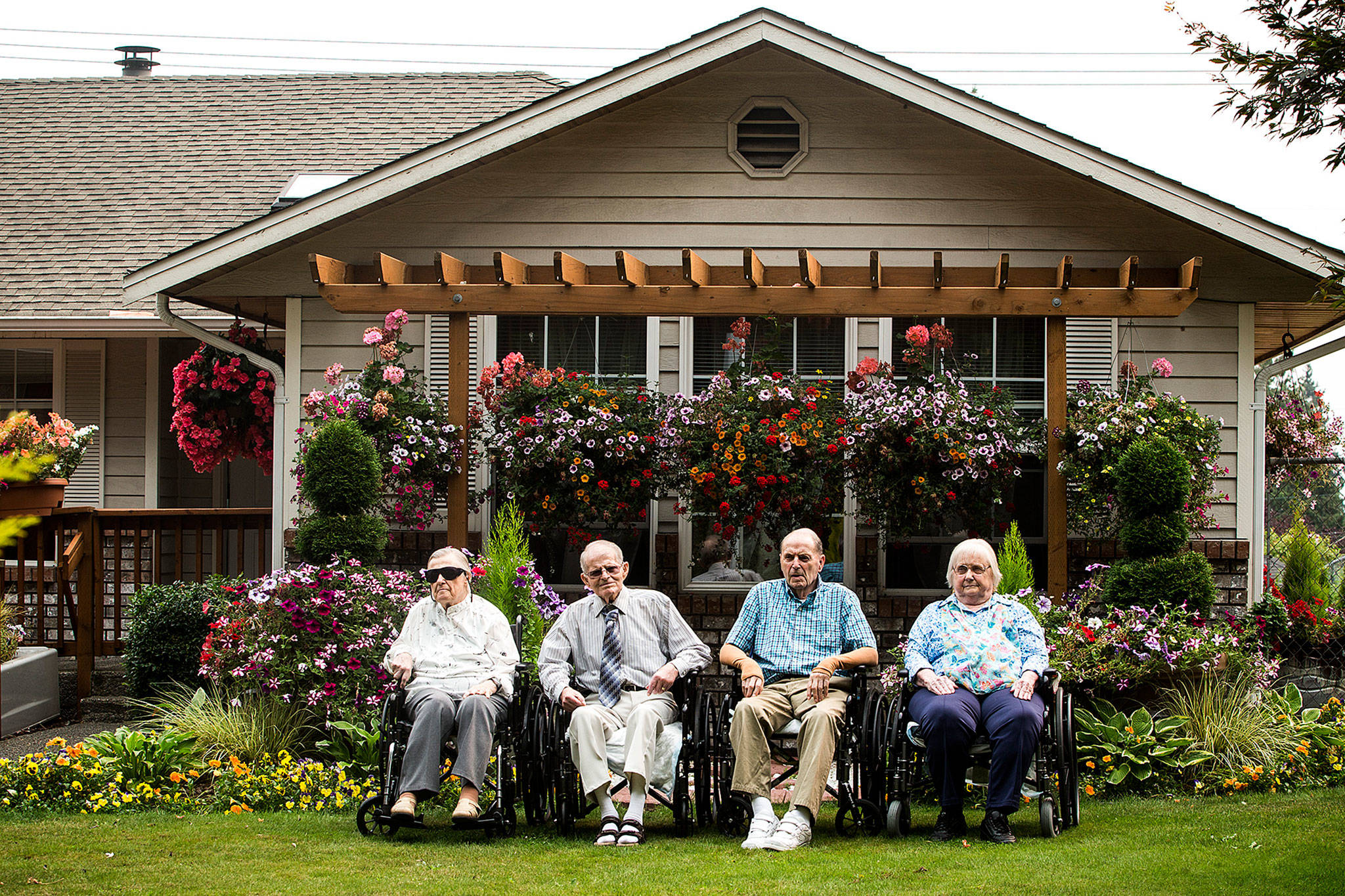 Golfview Adult Home residents (from left) Darlene Gorham, Daryl Finley, Lorne and Eleanore Blair have an extensive array of flowers to view while living at the Everett adult care home. (Ian Terry / The Herald)