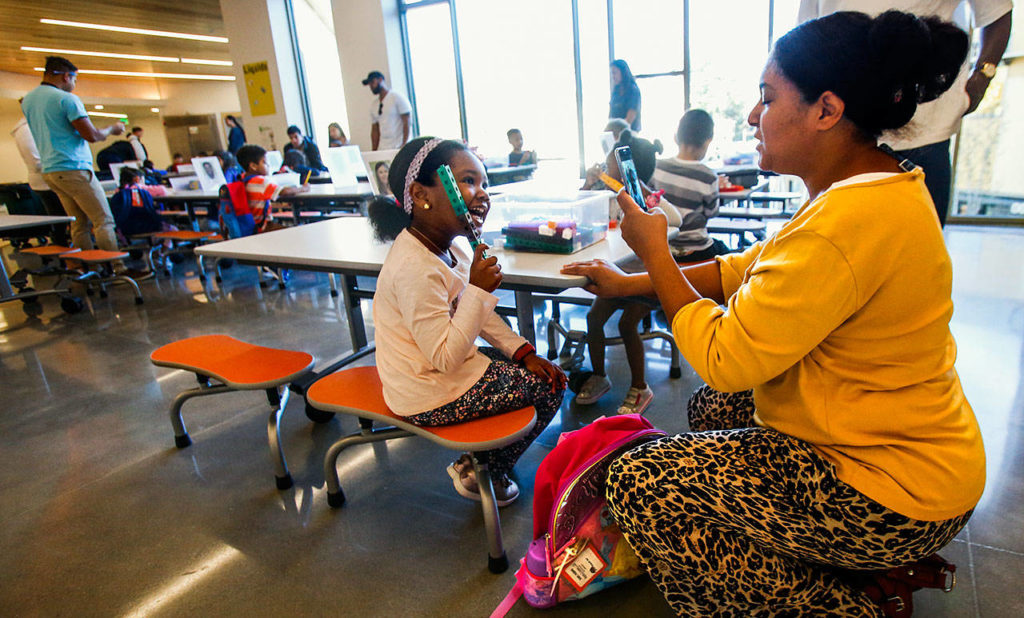 While her mother, Nada Semlali (right) takes a few photographs, Yasmine Diaby, 5, plays with a bin of blocks at one of the tables in a common area just outside several classrooms on the second floor of Mukilteo School District’s new all-kindergarten school, Pathfinder Kindergarten. (Dan Bates / The Herald)
