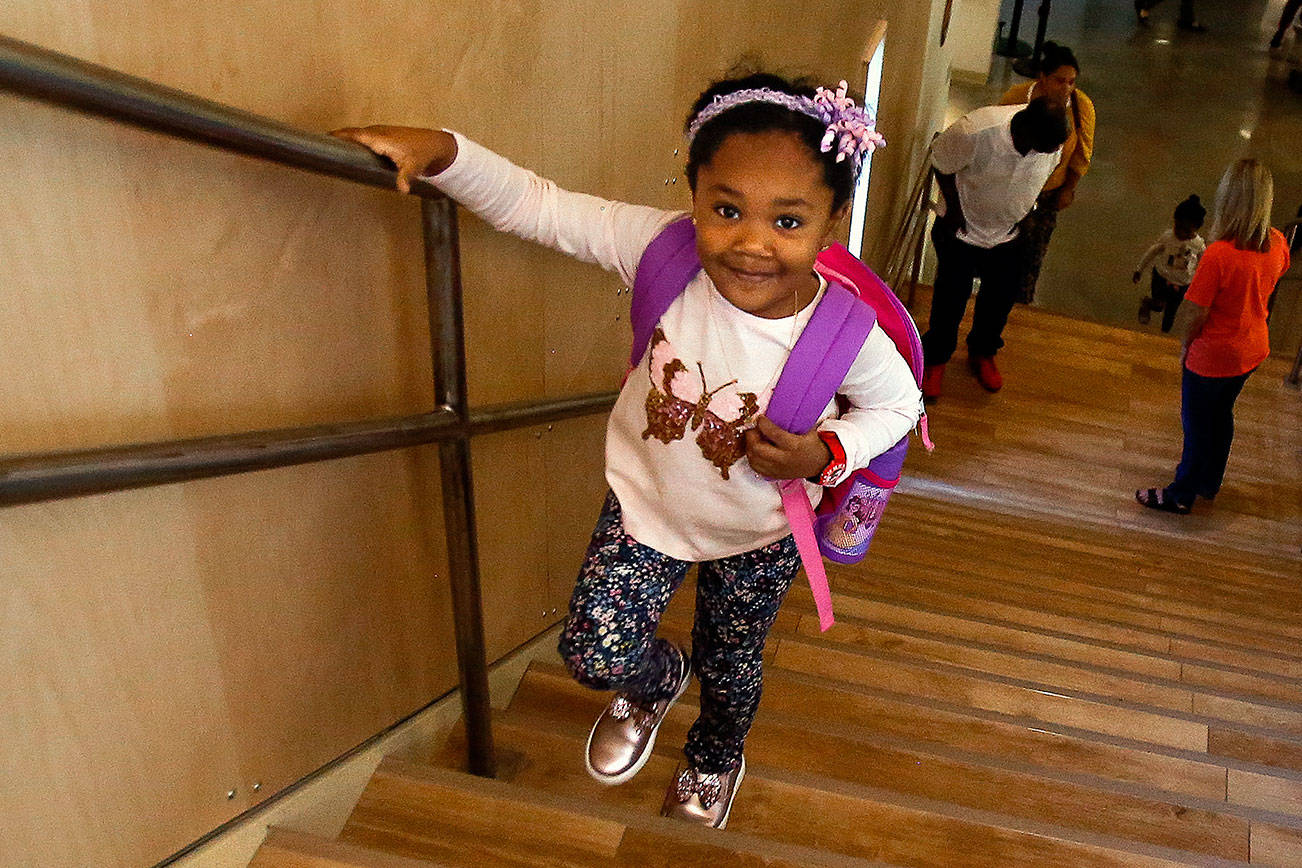With her mother and father and little sister still near the bottom, Yasmine Diaby, 5, quickly climbs the stairs to the second floor of Mukilteo School Districts new Pathfinder Kindergarten. (Dan Bates / The Herald)