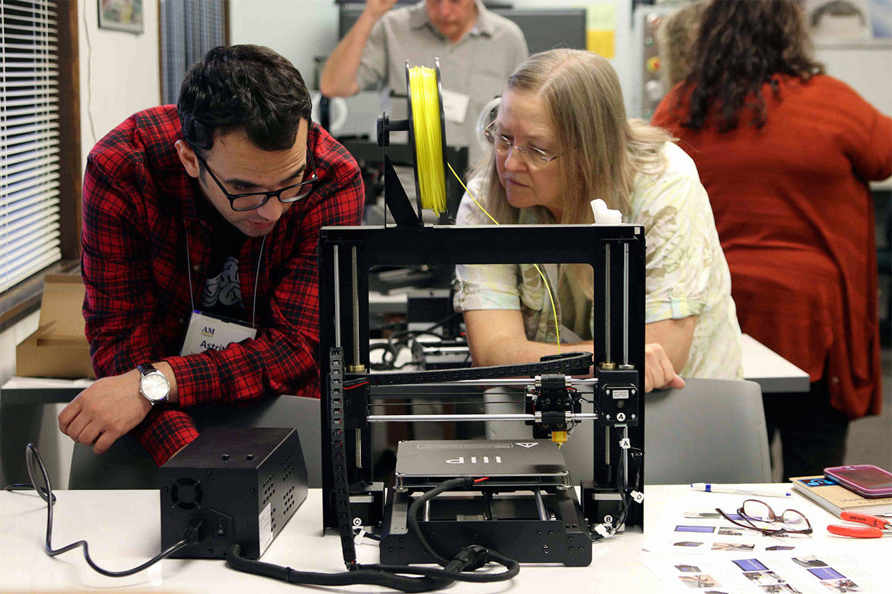 Astrit Imeri, a Tennessee Tech University grad student, shows Edmonds Heights K-12 teacher Cathy Webb how to troubleshoot 3D printer mechanical errors at a two-day workshop hosted at Edmonds Community College. (Photo contributed by Edmonds Community College)