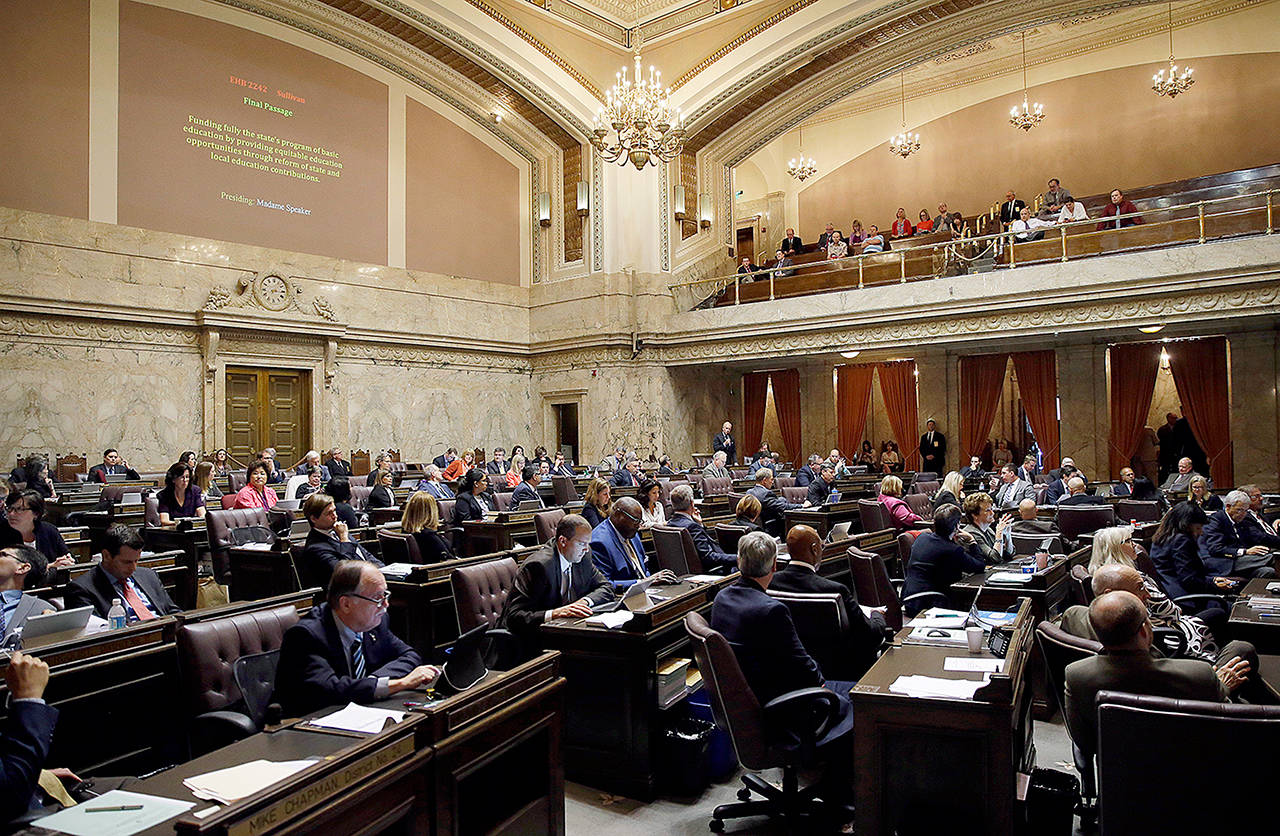 Representatives work on the House floor during discussion of a bill to fully fund education in Washington at the Capitol in Olympia in June. A coalition of news organizations led by The Associated Press is suing the Legislature over its assertion that state lawmakers aren’t required to release to the public daily schedules, text messages, emails and other materials related to their work. (AP Photo/Ted S. Warren, File)