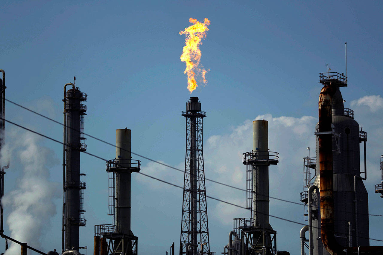 In this Thursday, Aug. 31, 2017, photo, a flame burns at the Shell Deer Park oil refinery in Deer Park, Texas. Companies have reported that roughly two dozen storage tanks holding crude oil, gasoline and other fuels collapsed or otherwise failed during Harvey, spilling a combined 140,000 gallons of fuel, according to an Associated Press analysis of state and federal accident databases. (AP Photo/Gregory Bull, File)