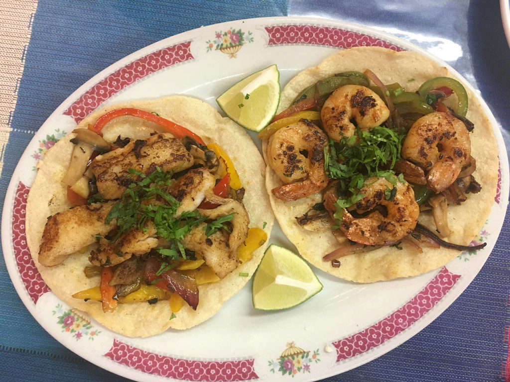 A fish taco and a shrimp taco comes with sauteed peppers, onion and mushroom and a whole lot of flavor at Ade’s Mexican Deli in Everett. (Ben Watanabe / The Herald)
