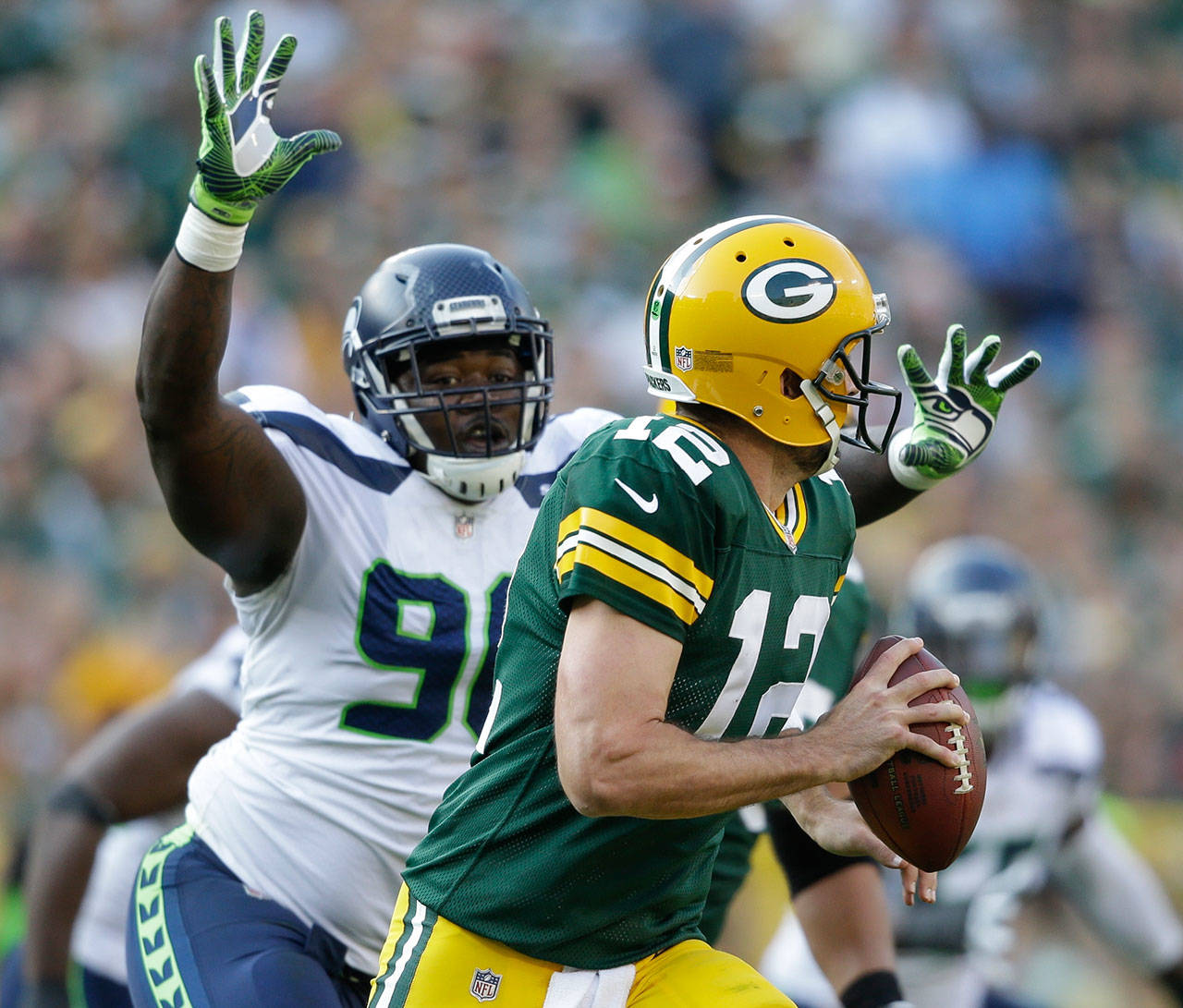 Green Bay quarterback Aaron Rodgers scrambles away from Seattle’s Jarran Reed during the second half of Sunday’s NFL game in Green Bay. (AP Photo/Jeffrey Phelps)