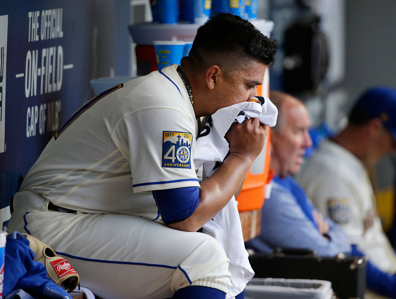 Seattle Mariners starting pitcher Erasmo Ramirez sits in the dugout after he was pulled in the seventh inning of a baseball game against the Los Angeles Angels in Seattle. (AP Photo/Ted S. Warren)