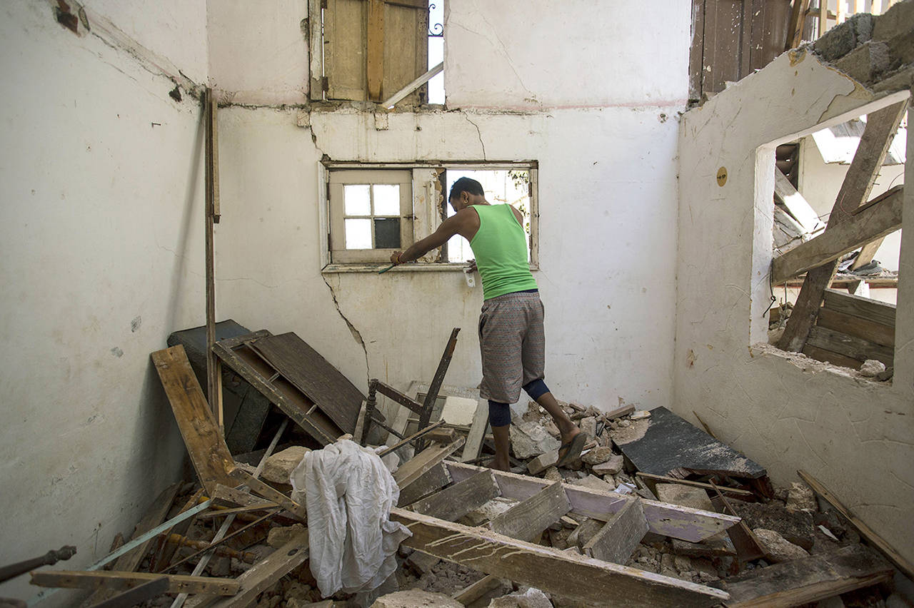 A resident steps on rubble at his collapsed apartment building where two people died during the passing of Hurricane Irma in Havana, Cuba, on Monday. (AP Photo/Desmond Boylan)