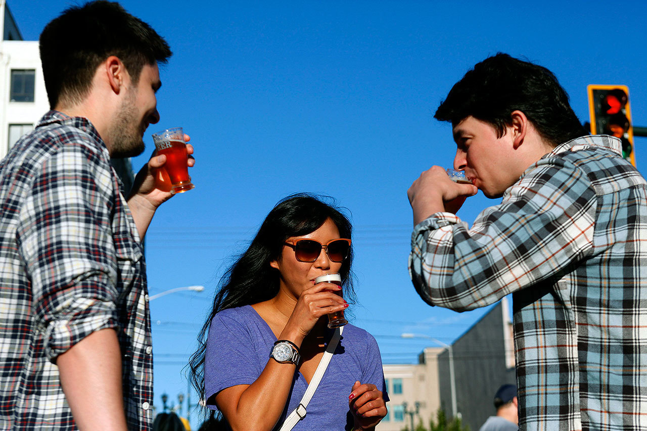 Tim Janson, Kathy Sundrara and Arrow Mestas taste beer during the Everett Craft Beer Festival in 2013. The festival, which left for the Tri-Cities after five years in Everett, has essentially been replaced by the new Upper Left Beerfest, which is Sept. 16-17. (Genna Martin/Herald File)