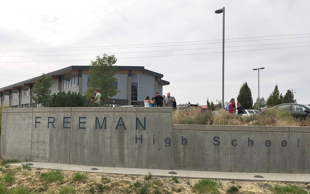 People gather outside of Freeman High School after reports of a shooting at the school in Rockford on Wednesday. (KHQ via AP)