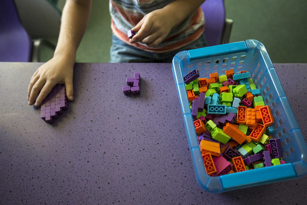 Joshua Latimer, 7, builds Legos at Another Best Child Care in Everett on Friday. (Ian Terry / The Herald)
