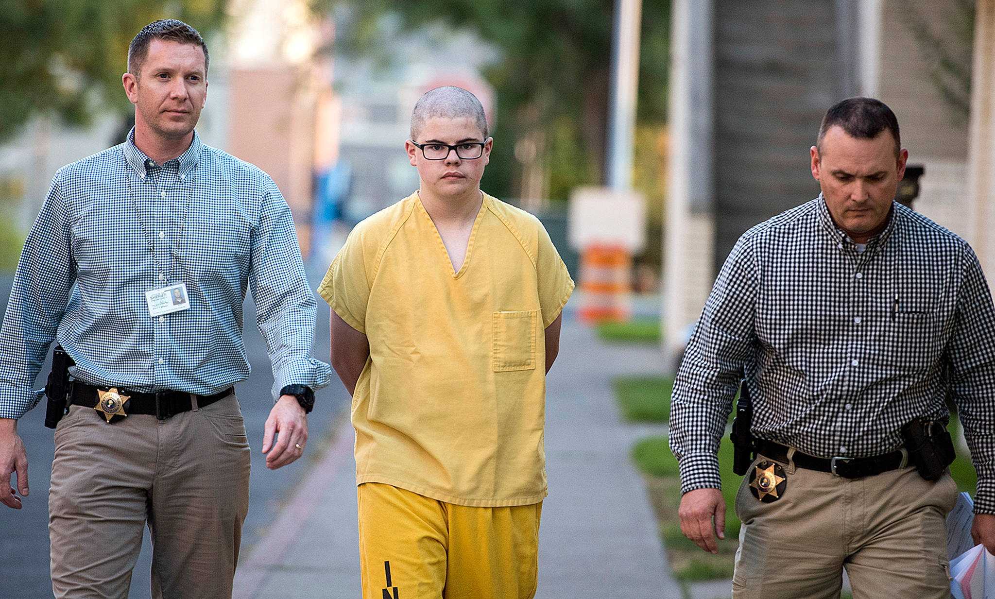 Spokane County Sheriff’s deputies escort Caleb Sharpe to the Juvenile Detention Center in Spokane on Thursday. Authorities say Sharpe opened fire Wednesday in a hallway at Freeman High School in Rockford, south of Spokane, killing a classmate who confronted him and wounding three others before being stopped by a custodian. (Colin Mulvany/The Spokesman-Review via AP)