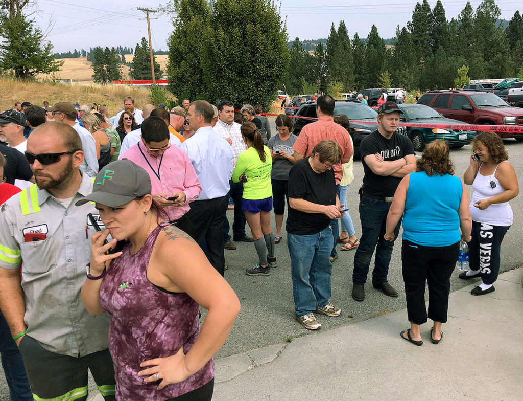 Parents gather in the parking lot behind Freeman High School in Rockford, Washington, to wait for their kids after a deadly shooting at the high school Wednesday. (Dan Pelle/The Spokesman-Review via AP) 
