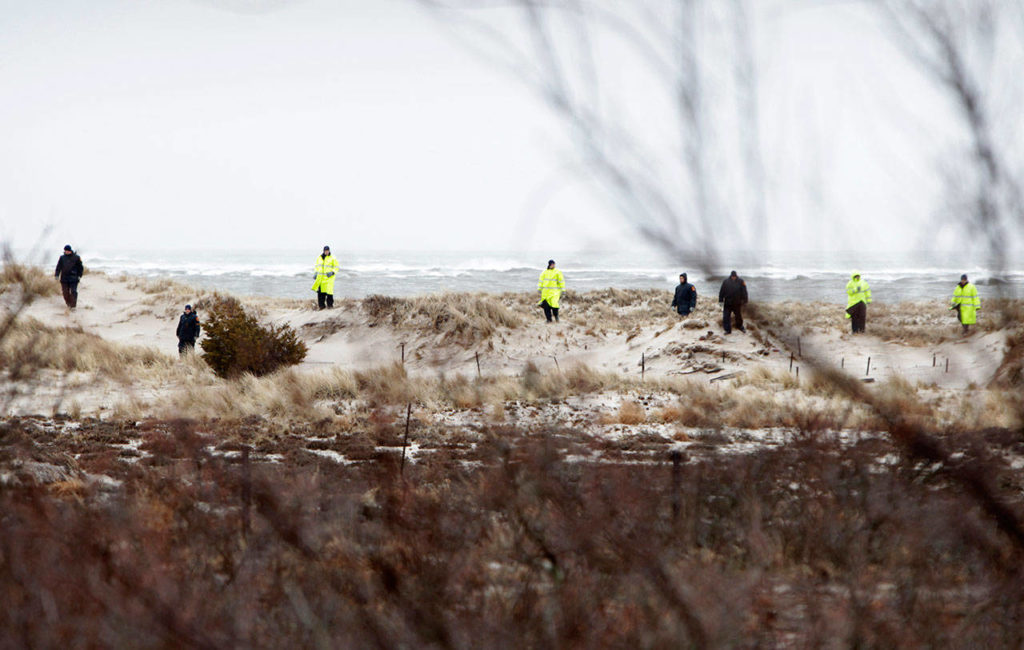 In this April 5, 2011 file photo, emergency personnel search the dunes and scrub near the ocean in Oak Beach, N.Y., across the road from where eight bodies where found. The Suffolk County Assistant District Attorney said a Long Island carpenter, recently sentenced for killing two prostitutes in the early 1990s, may be responsible for killing at least one of 10 victims whose remains have been found along a Long Island beach highway. (AP Photo/Seth Wenig, File)
