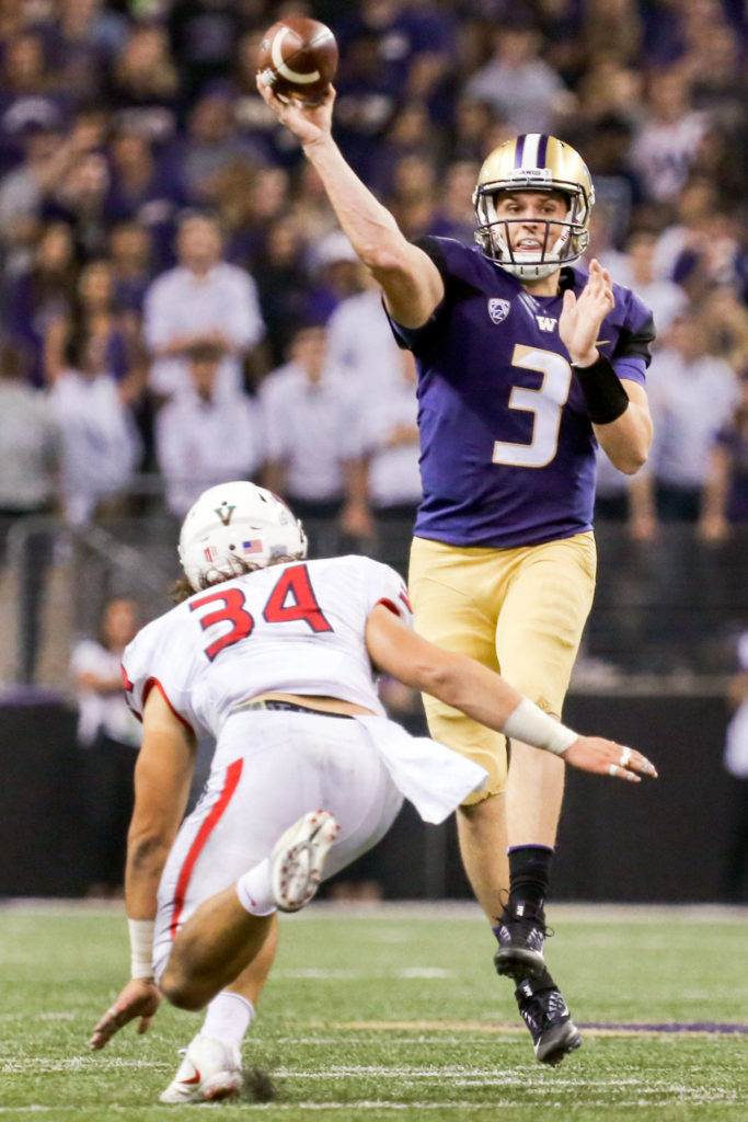 Washington’s Jake Browning makes a pass with Fresno State’s George Helmuth closing on Sept. 16, 2017, at Husky Stadium in Seattle. (Kevin Clark / The Herald)
