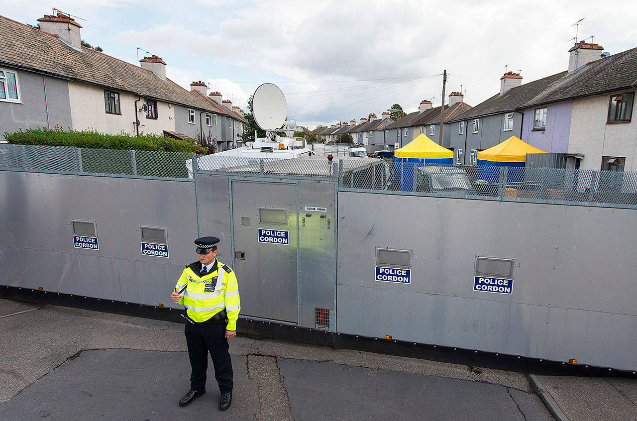 A police officer stands by a cordon on Monday in Sunbury-on-Thames, a London suburb where officials searched the home of a couple who fostered two suspects in last week’s subway bombing. (Dominic Lipinski/PA via AP)