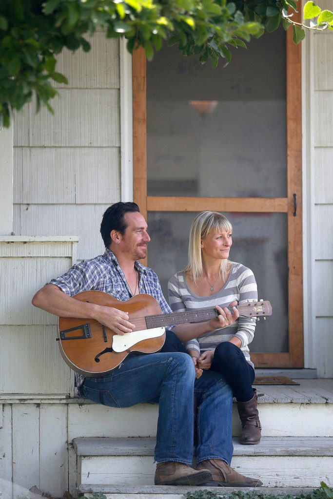 Josh and Genevieve Clauson sit on the front steps of their home near Conway. (Mark Mulligan / Herald File)
