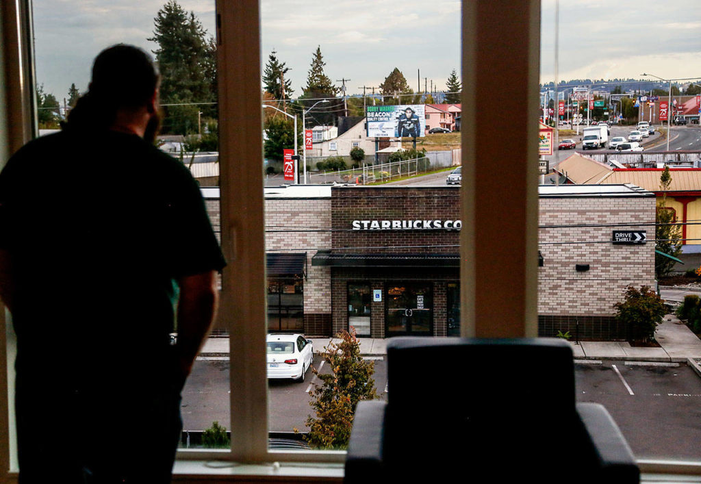 Chris Reilly, 22, looks out from his apartment on the third floor of Cedar Hall. A coffee drinker, he is glad to be located so near a Starbucks along the southern edge of the EvCC campus. (Dan Bates / The Herald)
