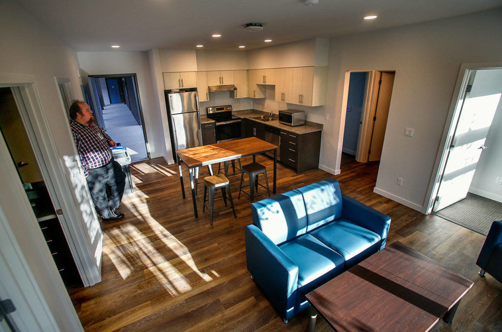 Mike Bowers, director of student housing at EvCC, shows a four-bedroom suite in the new Cedar Hall. Single bedrooms in each corner open onto a common kitchen and living room. Two bathrooms, one on each side, separate the bedrooms. (Dan Bates / The Herald)
