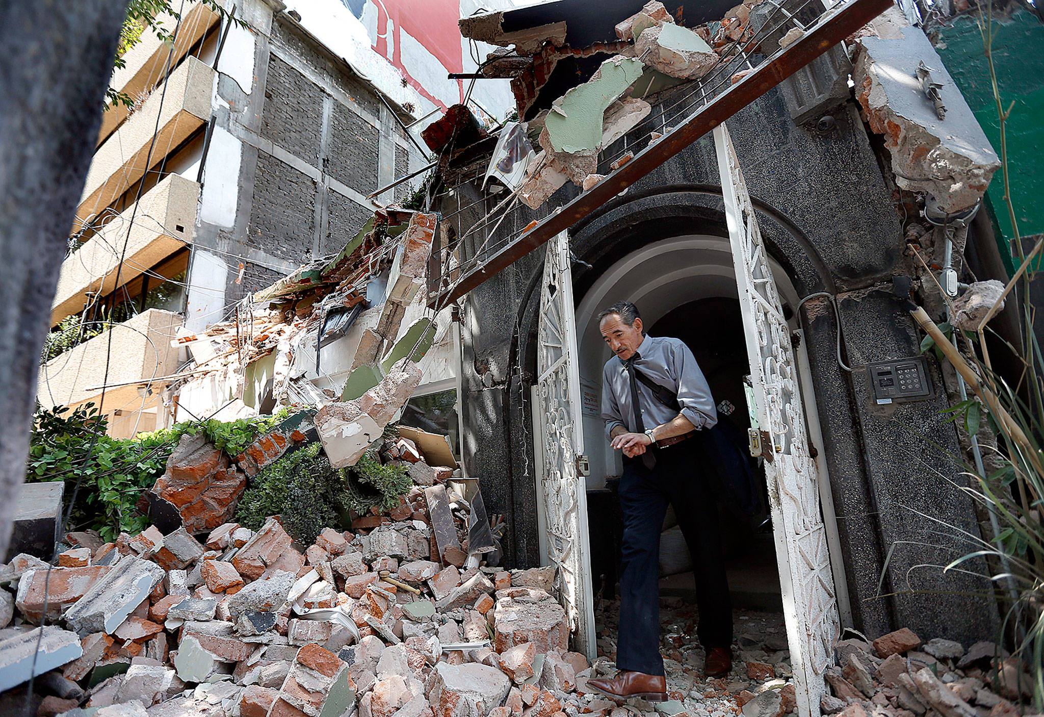 A man walks out of the door frame of a building that collapsed after an earthquake in Mexico City on Tuesday. (AP Photo/Marco Ugarte)