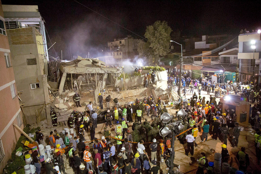 Volunteers and rescue workers search for children trapped inside at the collapsed Enrique Rebsamen school in Mexico City on Tuesday. A wing of the three-story building collapsed into a massive pancake of concrete floor slabs, killing scores of students. (AP Photo/Gerardo Carrillo) 
