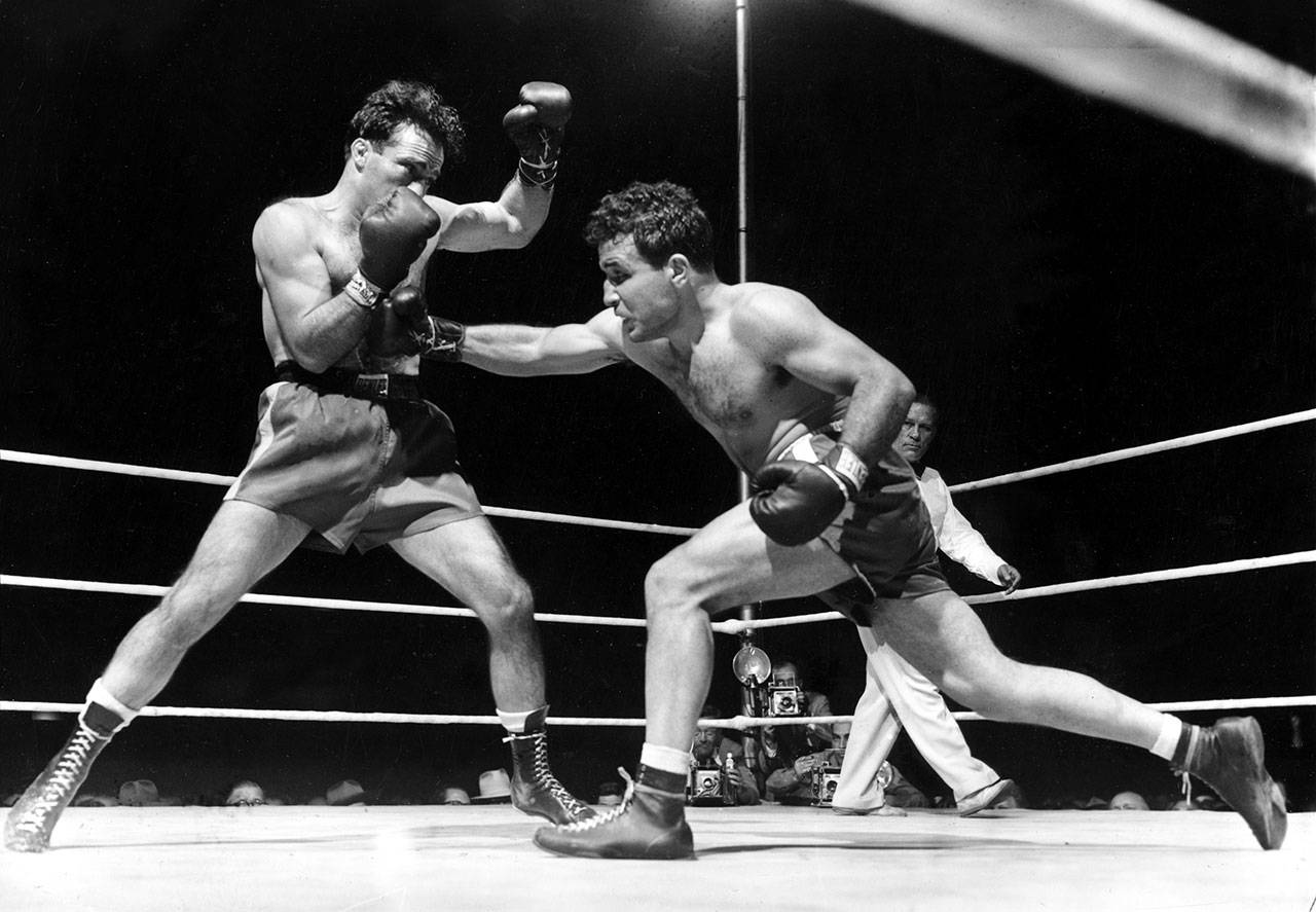 This photo from June 16, 1949, shows Jake LaMotta (right) fighting Marcel Cerdan in Briggs Stadium in Detroit. LaMotta knocked out Cerdan in the 10th round to become the world middleweight champion. (AP Photo/File)