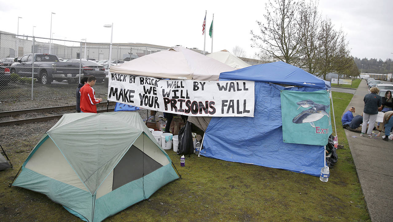 In this April 12 photo, students and other immigration-rights supporters gather outside tents by the Northwest Detention Center in Tacoma. (AP Photo/Ted S. Warren, File)