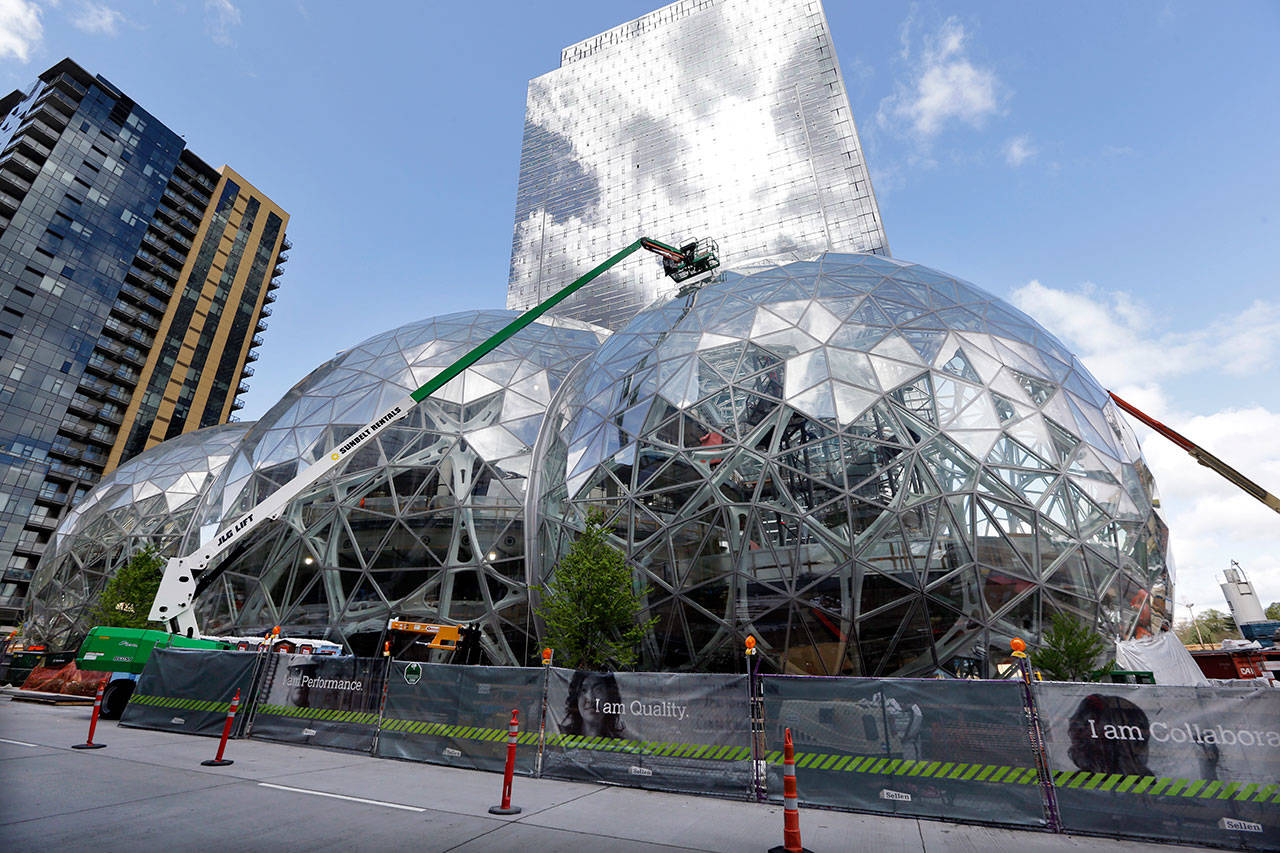 Construction continues on three large, glass-covered domes as part of an expansion of the Amazon.com campus in downtown Seattle in this file photo from April. Amazon said earlier this month that it will spend more than $5 billion to build another headquarters in North America to house as many as 50,000 employees. It plans to stay in its sprawling Seattle headquarters and the new space will be “a full equal” of its current home, said founder and CEO Jeff Bezos. (Elaine Thompson/Associated Press)
