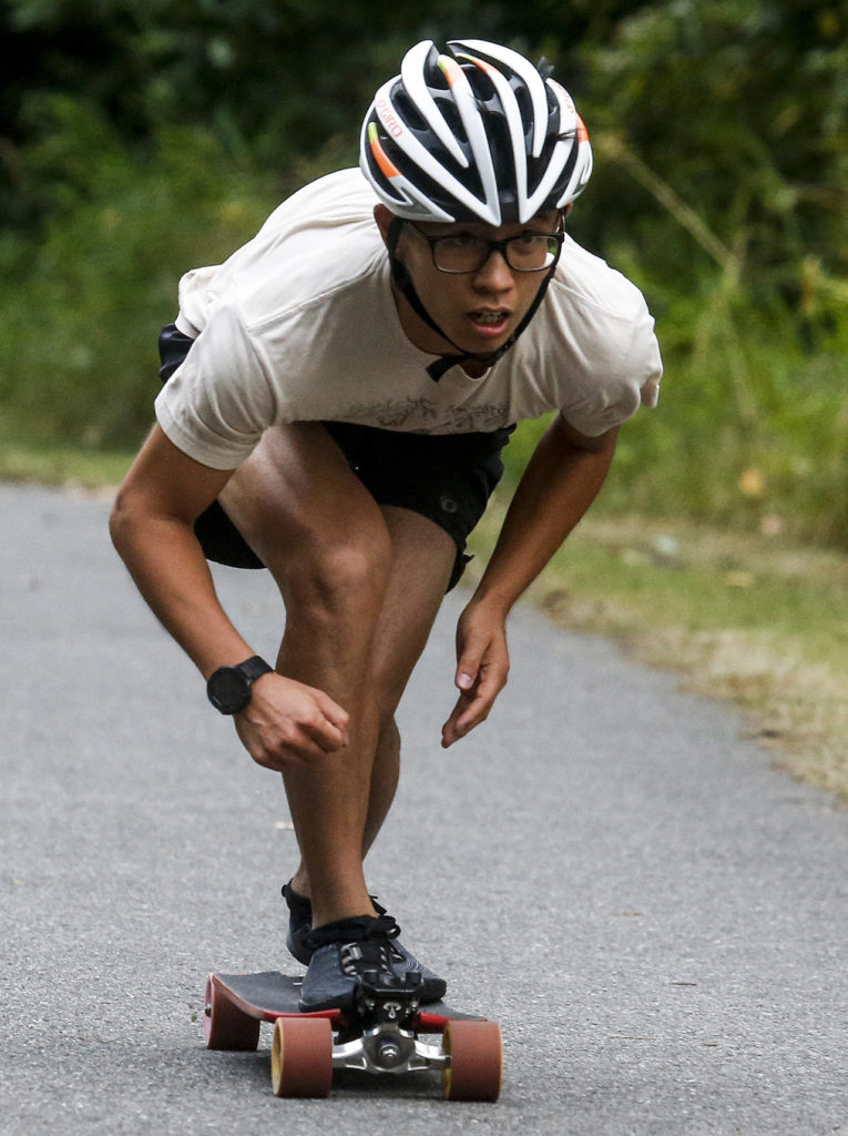 Saturday evening’s 8.5 mile race winner Kyle Yan, of New York, tucks before crossing the finish line with a time of 30 minutes and 57 seconds on an out and back course on the Centennial Trail in Arlington. (Ian Terry / The Herald)
