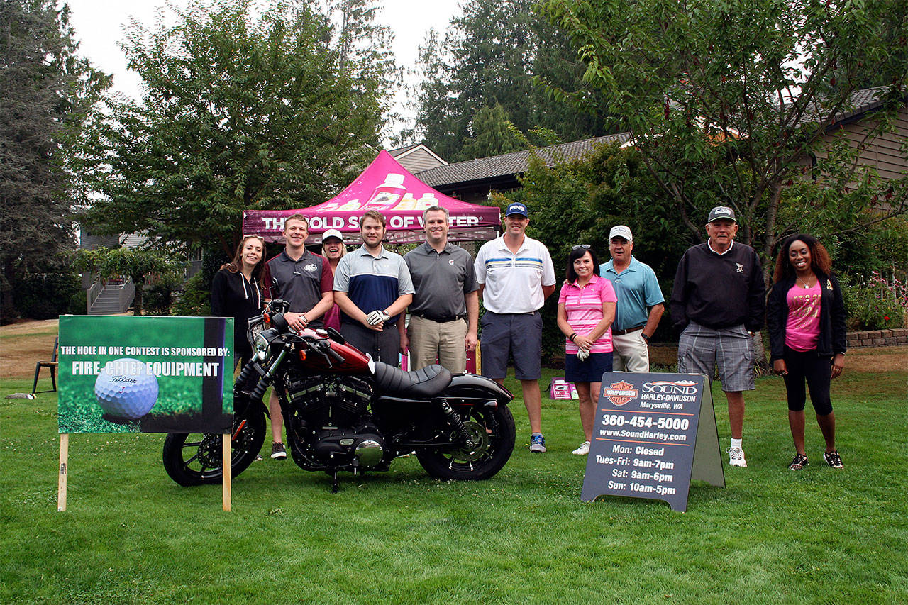 A Pink the Rink golf tournament fundraiser was held Sept. 7 at Gleneagle Golf Course in Arlington and raised over $30,000 to benefit breast cancer research. A motorcycle was the prize for a hole-in-one contest, thanks to Sound Harley-Davidson and Fire Chief Equipment Co. (Contributed photo)