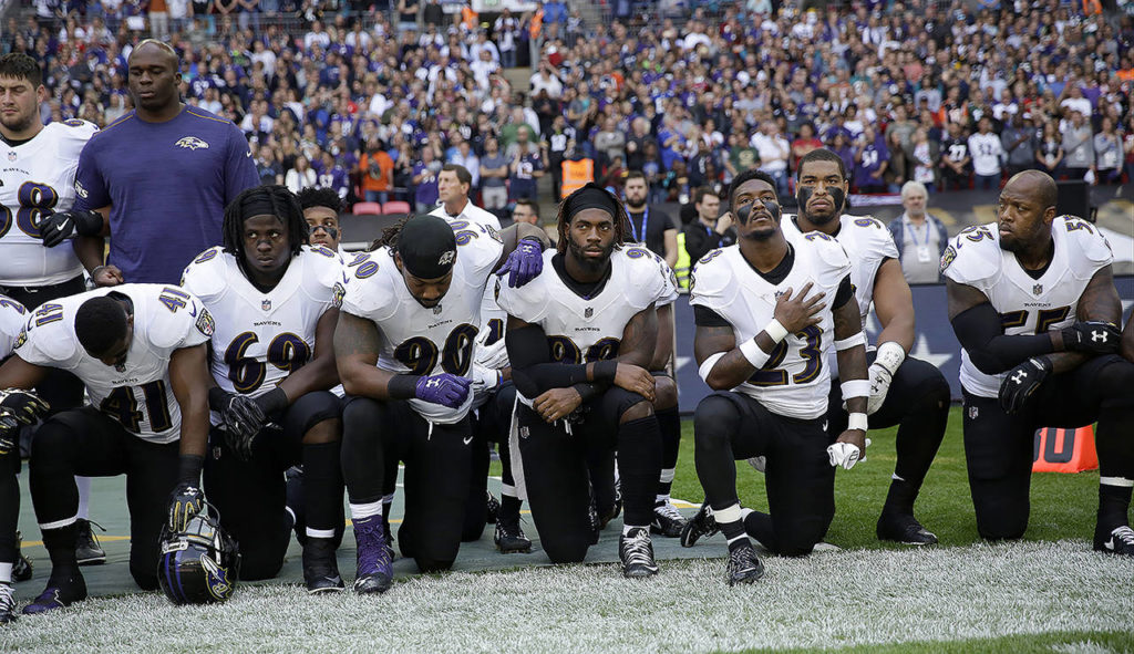 Baltimore Ravens players kneel down during the playing of the U.S. national anthem before an NFL football game against the Jacksonville Jaguars at Wembley Stadium in London on Sunday. (AP Photo/Matt Dunham)
