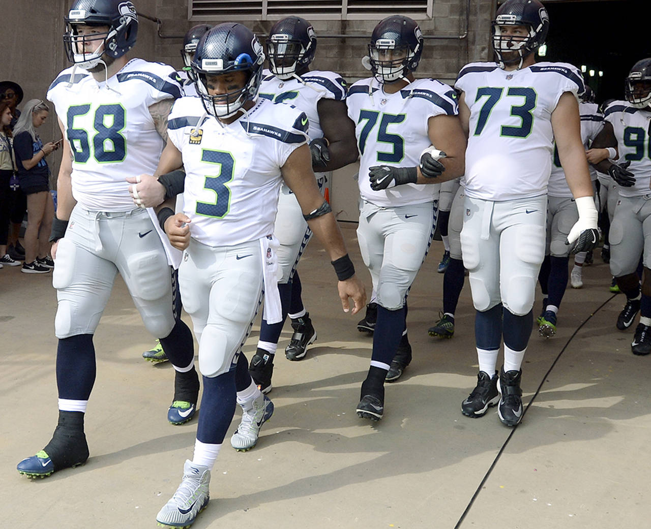 Seattle Seahawks quarterback Russell Wilson (3) and center Justin Britt (68) walk to the field with arms linked after the national anthem had been played before an NFL football game between the Seahawks and the Tennessee Titans on Sunday in Nashville, Tennessee. Neither team was present on the field for the playing of the anthem. (AP Photo/Mark Zaleski)