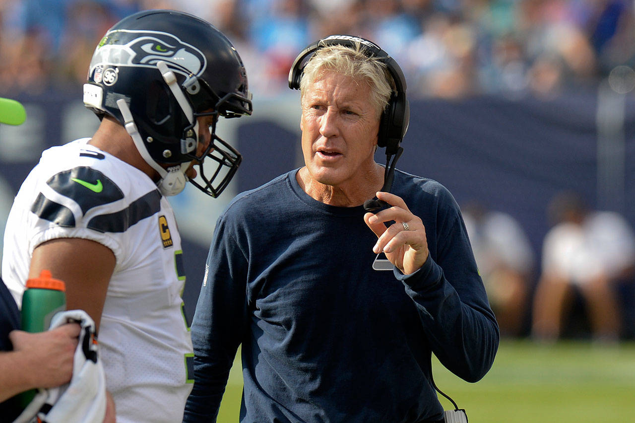Seattle Seahawks head coach Pete Carroll talks with quarterback Russell Wilson in the first half of Sunday’s game in Nashville, Tennessee. (AP Photo/Mark Zaleski)