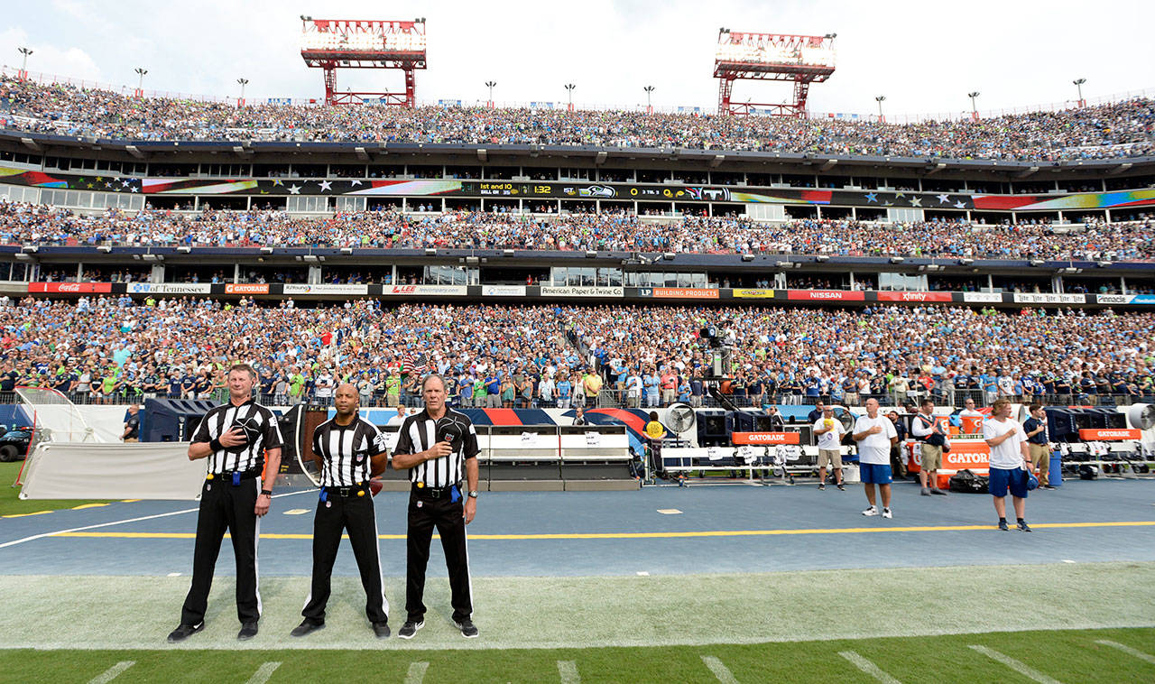 Officials stand on the sideline of the Seattle Seahawks during the playing of the national anthem before Sunday’s game in Nashville, Tenn. Neither team came out onto the field for the anthem. (AP Photo/Mark Zaleski)