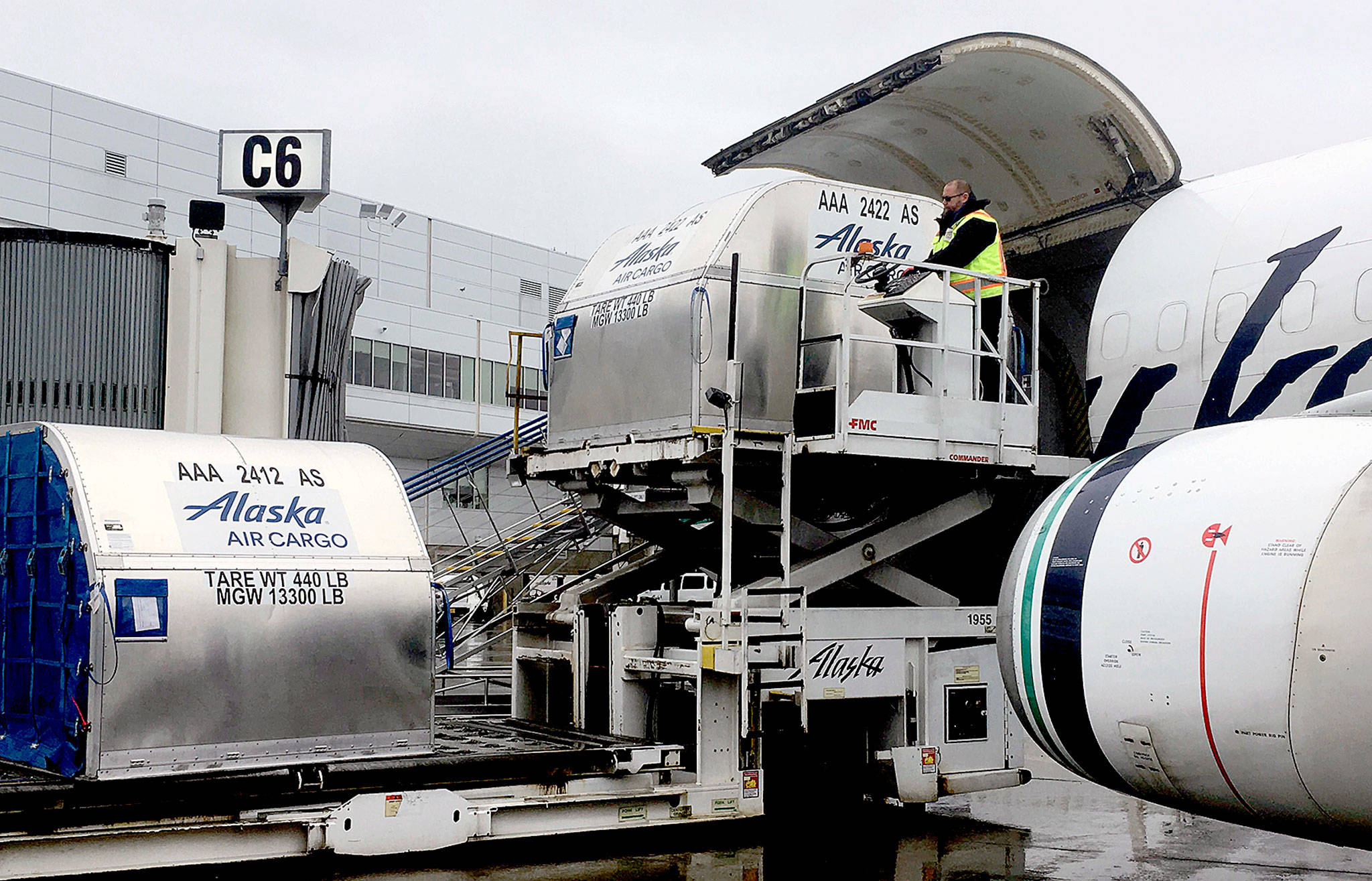 Alaska Airlines employee Jeff Ferguson loads cargo into the middle of a passenger plane at Ted Stevens Anchorage International Airport in Anchorage, Alaska. The airline is retiring its “combi” planes — Boeing 737-400s designed to carry both cargo and passengers. (AP Photo/Mark Thiessen)