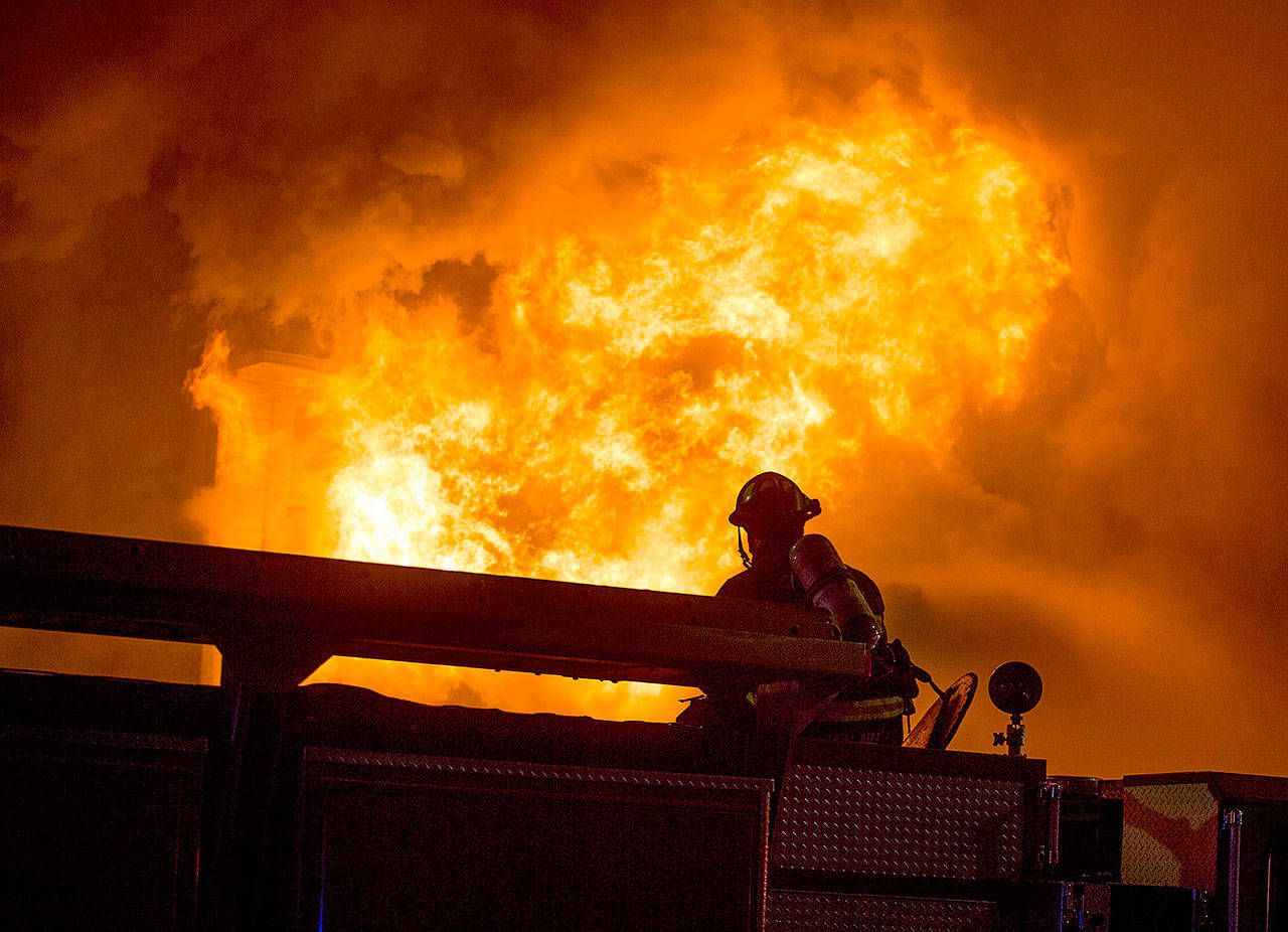 Flames burst out from the front face of Everett Office Furniture on Broadway on Monday in Everett. The fire caused damage estimated at $1.5 million. (Andy Bronson / The Herald)