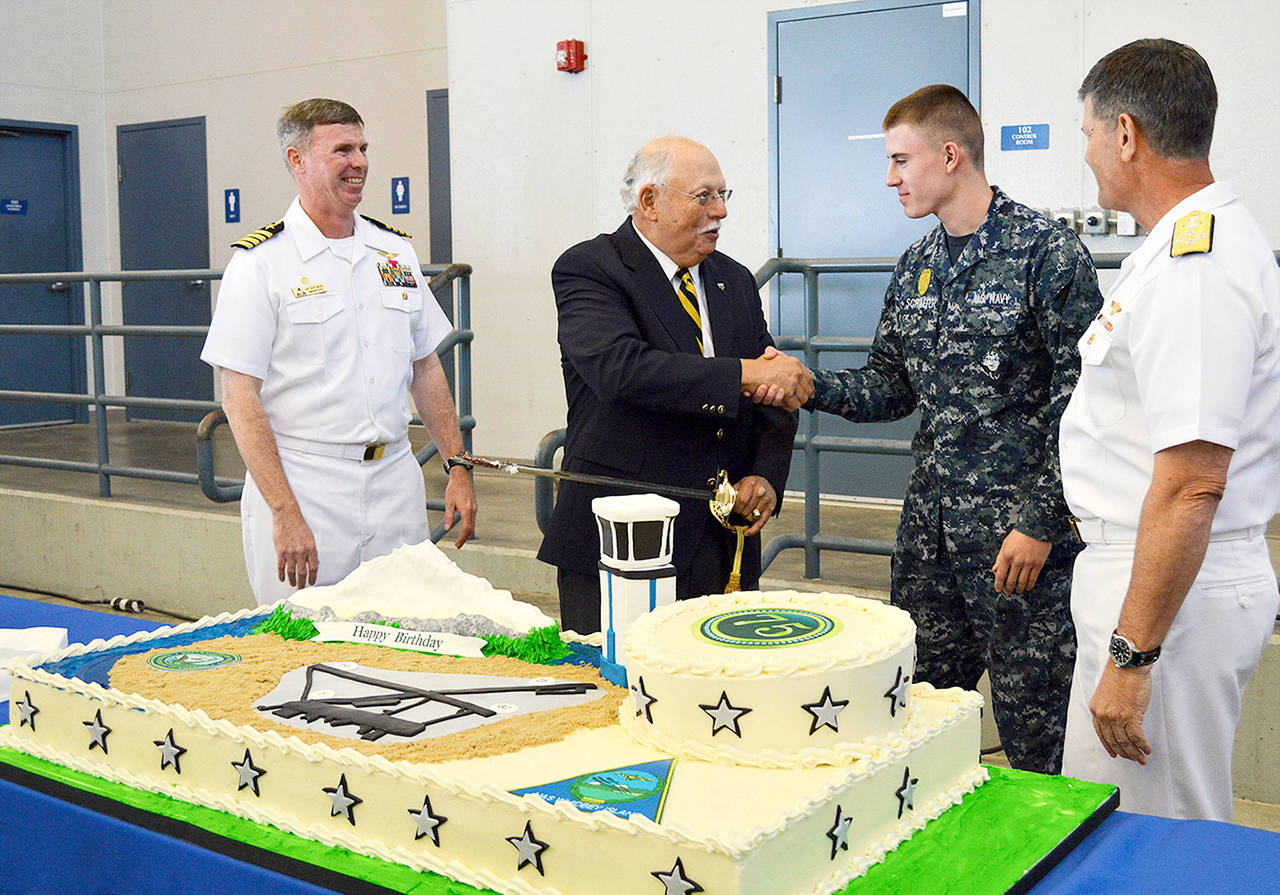 Helping to celebrate NAS Whidbey’s 75th anniversary Thursday are (from left) Capt. Geoffrey Moore, Dave Williams, Seaman Matthew Schaeffer and Adm. Bill Moran. Williams is the oldest person serving on the base and Schaeffer is the youngest. (Laura Guido / Whidbey News-Times)