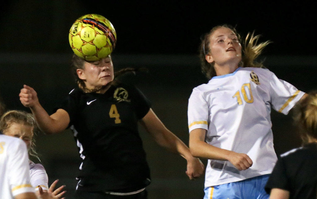 Lynnwood’s Cassidy O’Dell (left) heads the ball with Everett’s Kate Garton defending during a game Sept. 26, 2017, at Lincoln Field in Everett. (Kevin Clark / The Herald)
