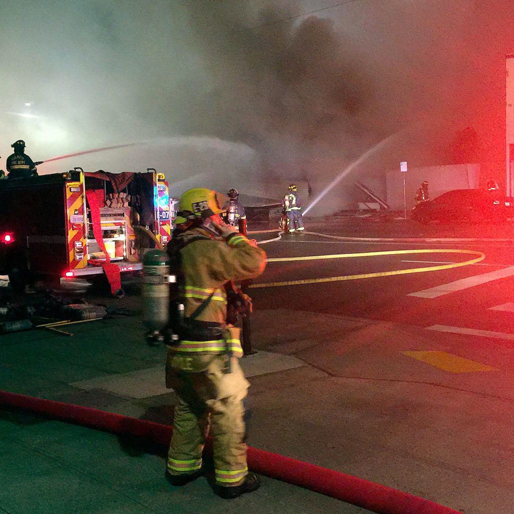 Firefighters pour water on a big fire on Broadway in Everett on Monday night. (Bill Pedigo / The Herald)
