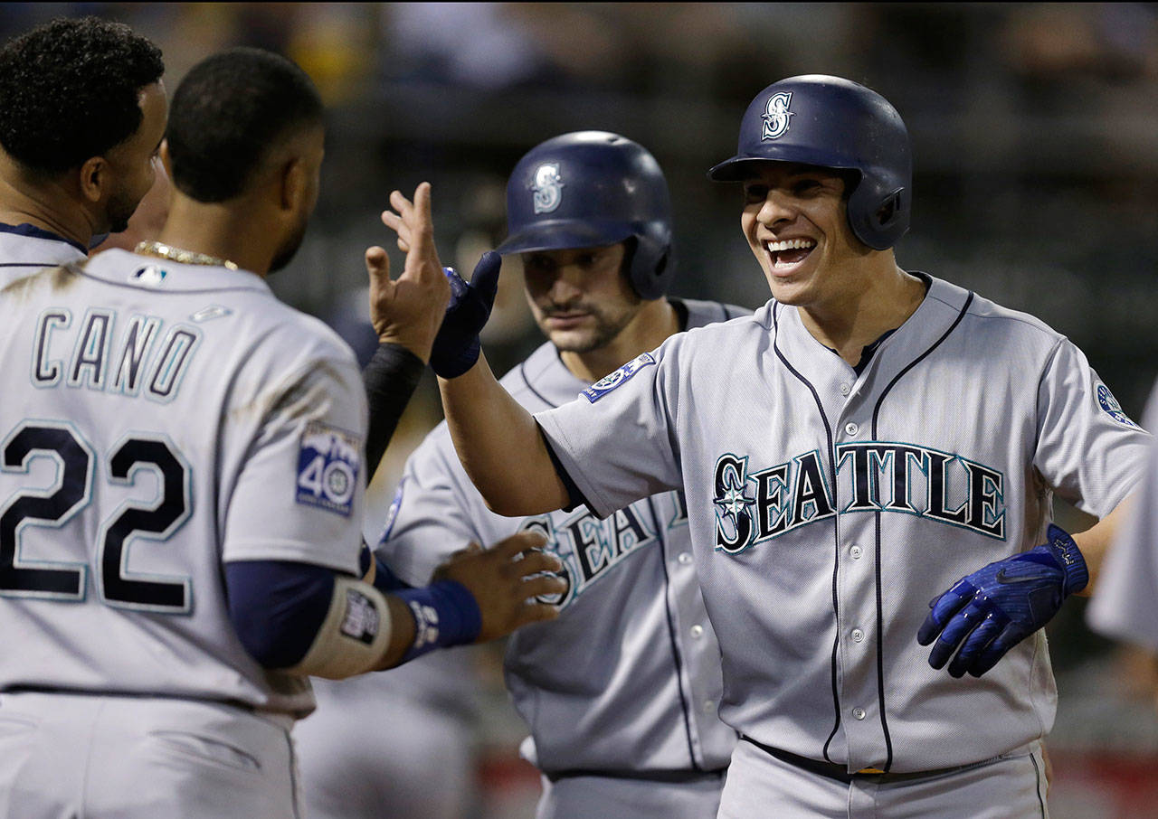 The Mariners’ Danny Valencia (right) celebrates with Robinson Cano (22) after hitting a three-run home run during the seventh inning of a game against the Athletics on Sept. 26, 2017, in Oakland, Calif. (AP Photo/Ben Margot)