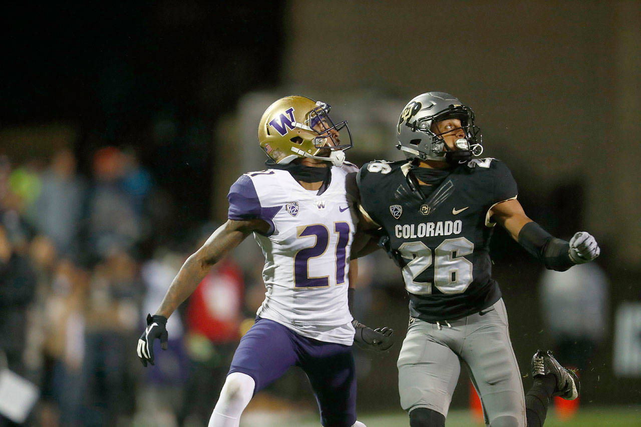 Washington wide receiver Quinten Pounds (21) and Colorado defensive back Isaiah Oliver (26) both search for the ball in the air in the first half of a game Sept. 23, 2017, in Boulder, Colo. (AP Photo/David Zalubowski)