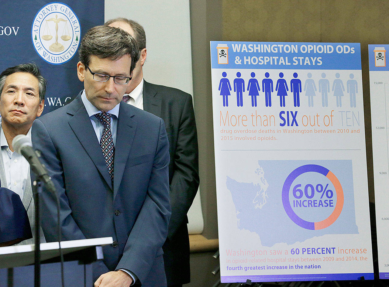 Washington Attorney General Bob Ferguson (second from left) listens to a question on Thursday in Seattle after announcing that the state and the city of Seattle are filing lawsuits against several makers of opioids, including Purdue Pharma. (AP Photo/Ted S. Warren)