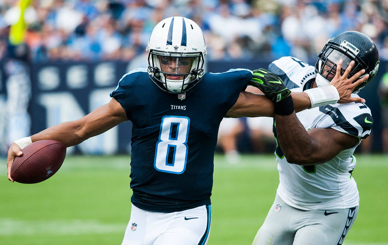 Titans quarterback Marcus Mariota (8) stiff-arms Seahawks middle linebacker Bobby Wagner (54) as he runs out of bounds during a game Sept. 24, 2017, in Nashville, Tenn. (Austin Anthony/Daily News via AP)