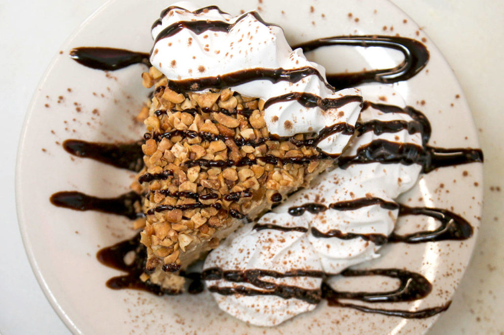 The pie is topped with whipped cream, chopped peanuts and chocolate syrup. (Kevin Clark / The Herald)
