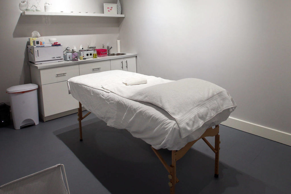 Private treatment rooms have a massage table, towel warmer and mood lighting. (Kevin Clark / The Herald)
