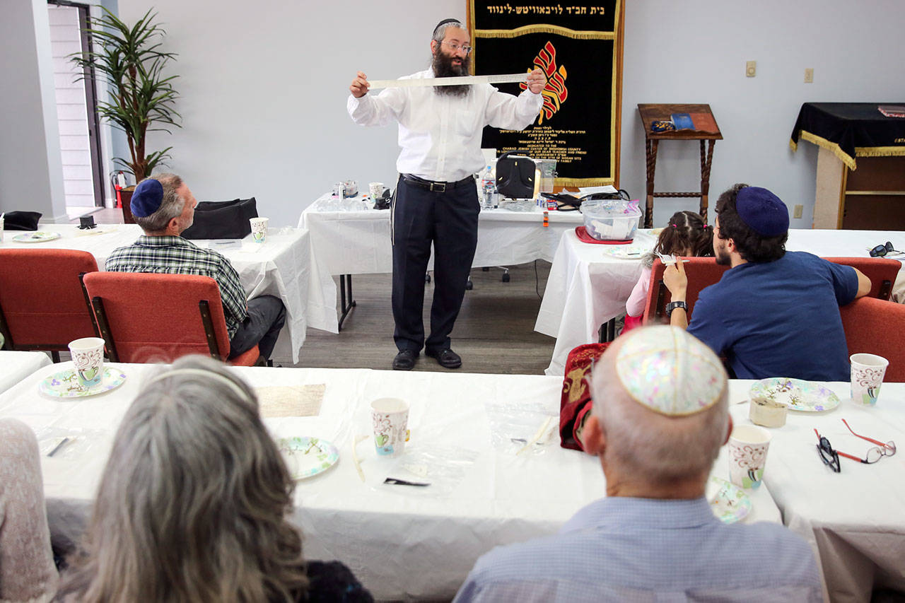 Rabbi Moshe Liberow, a Jewish scribe (Sofer) from Colorado Springs, explains the work of a scribe and tools of the trade at Chabad Center of Snohomish County in Lynnwood on Sept. 10. (Kevin Clark / The Herald)