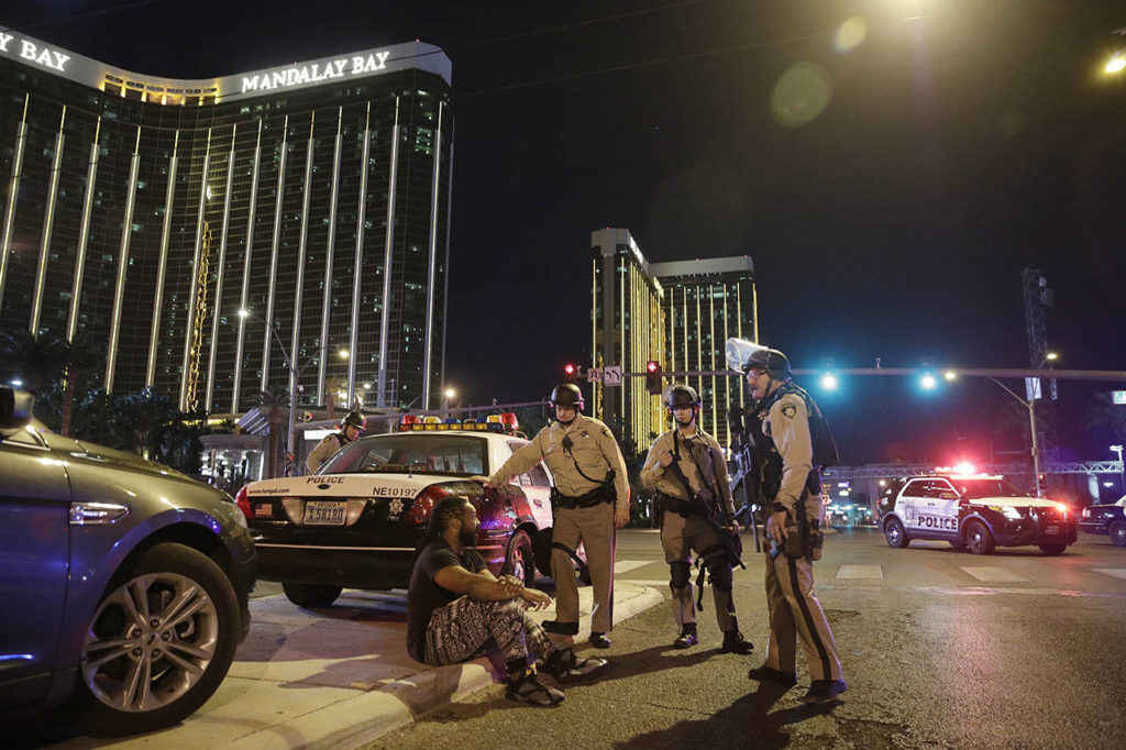 Police officers stand at the scene of a shooting near the Mandalay Bay resort and casino on the Las Vegas Strip on Sunday in Las Vegas. Multiple victims were being transported to hospitals after a shooting late Sunday at a music festival on the Las Vegas Strip. (AP Photo/John Locher)

