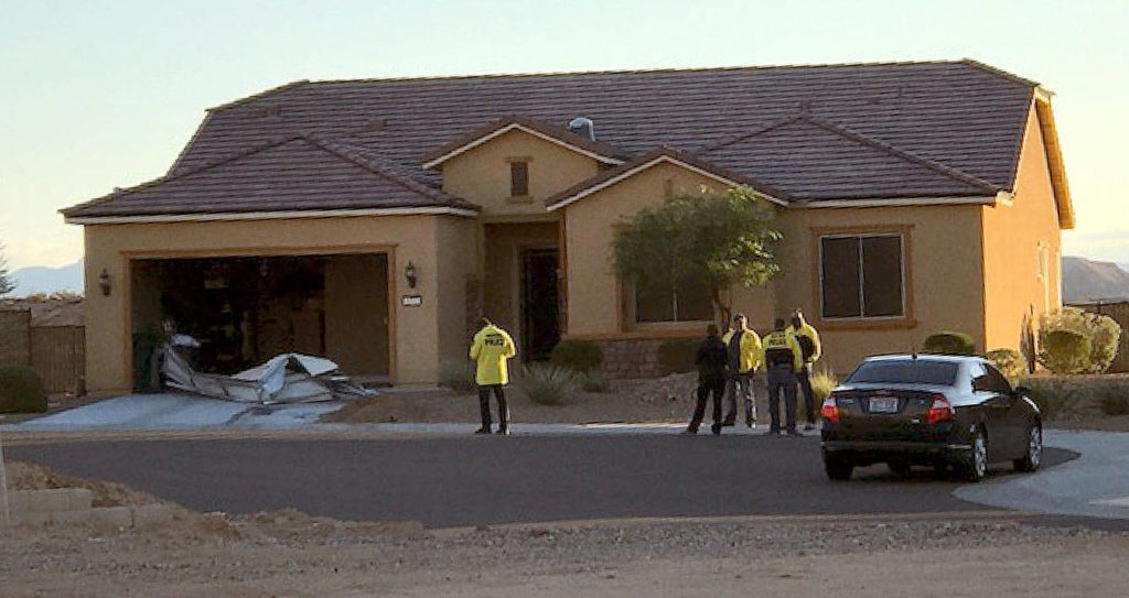 Police stand outside the home of Stephen Paddock on Monday in Mesquite, Nevada. Police identified Paddock as the gunman at a music festival Sunday evening. (Mesquite Police via AP) 
